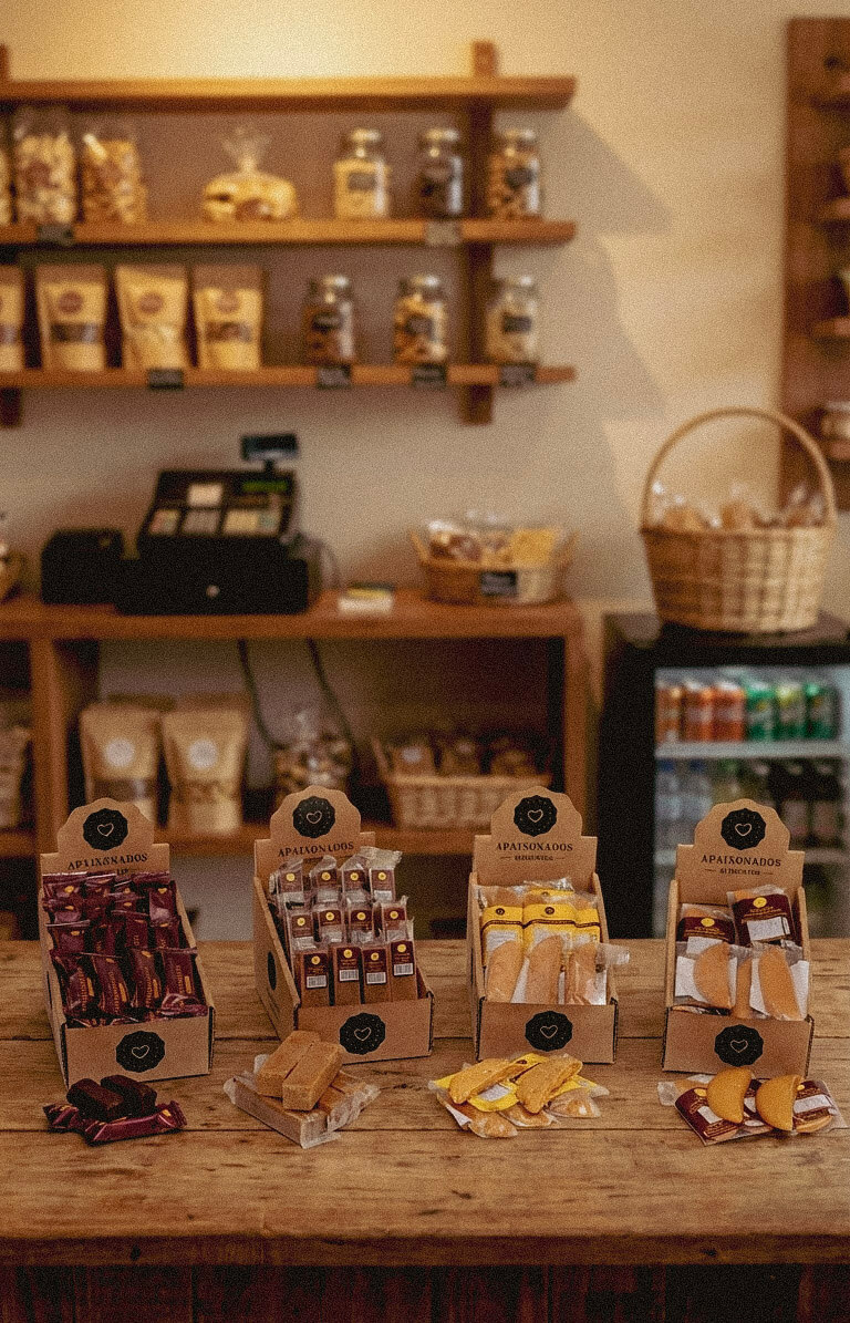Balcão de um estabelecimento com produtos da Apaixonados Alimentos: doce de leite, paçoca, cocada e bananinha
